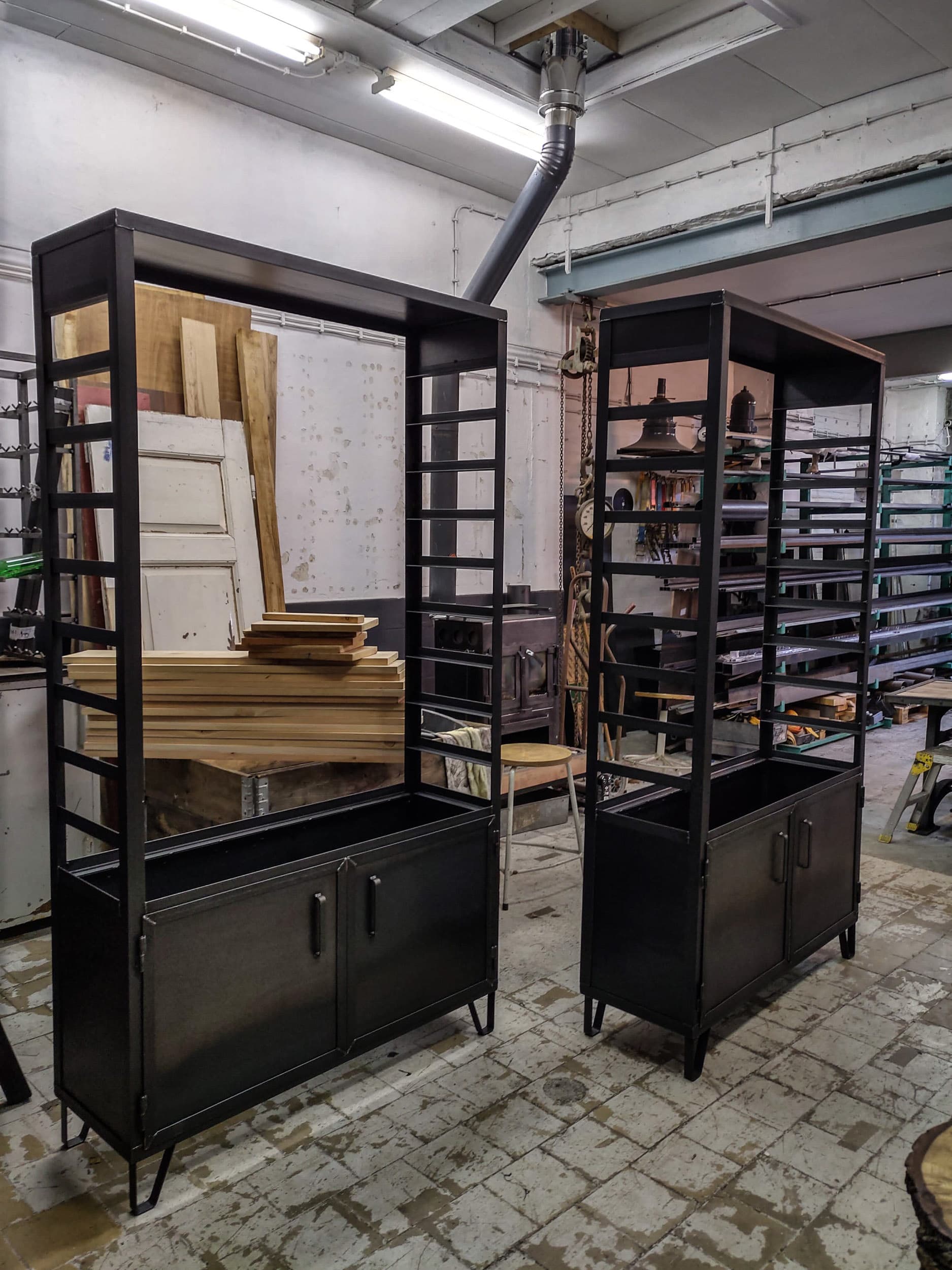 Twee stalen stellingkasten met open vakken boven en dichte onderkasten, klaar in de werkplaats.